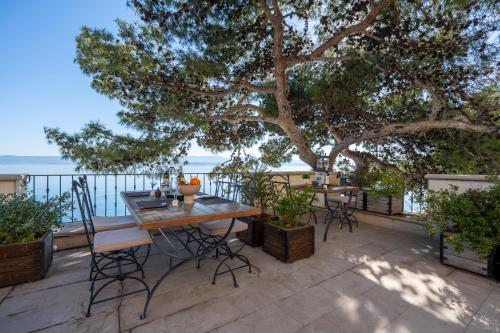 a patio with a table and chairs under a tree at Newly renovated Hotel Kastil in Bol