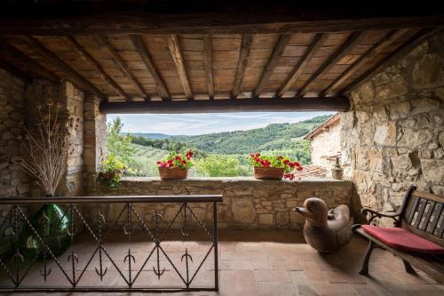 a patio with a table and a bench and a window at Podere Felceto in Panzano