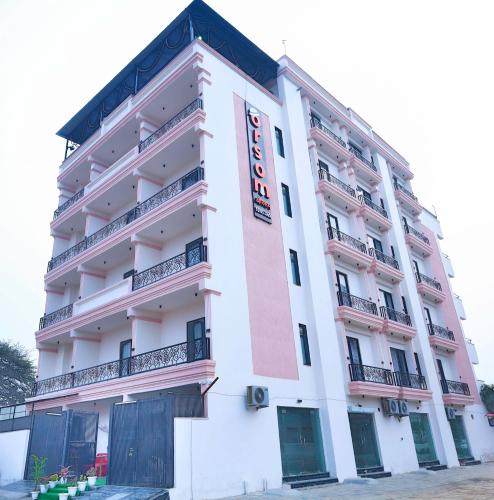 a large white building with a red and white at Orsom Stays Sassy Sector 53 in Gurgaon