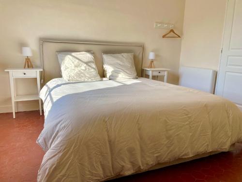 a bedroom with a large bed with white sheets and pillows at Maison & Jardin Coeur Luberon classé 4 étoiles in Peypin-dʼAigues