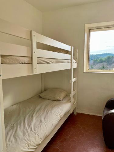 une chambre avec deux lits superposés et une fenêtre dans l'établissement Maison & Jardin Coeur Luberon classé 4 étoiles, à Peypin-dʼAigues