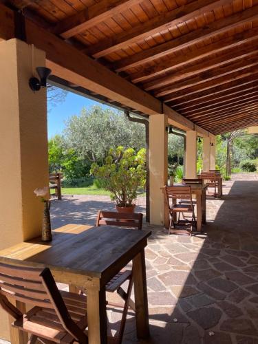 a porch with a wooden table and chairs on a patio at Botanea Guest House in Fonte Nuova