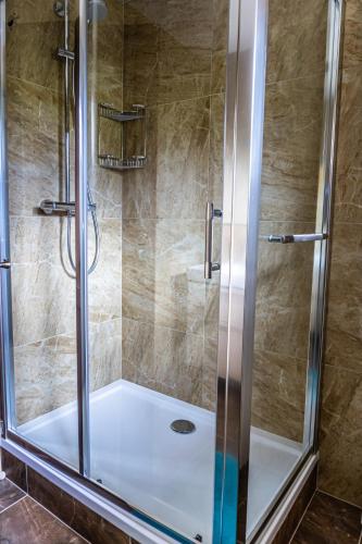 a shower with a glass door in a bathroom at Janiho Chata Bachledova dolina in Ždiar