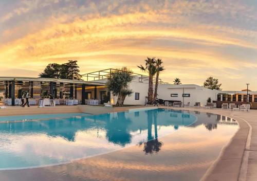 a large swimming pool in front of a building at Tenuta San Marco in Noto