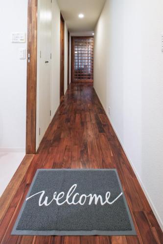 a welcome mat on the floor of a hallway at L -scene Centrally located in Matsumoto Maximum 8 people 2 min walk from Matsumoto Castle in Matsumoto