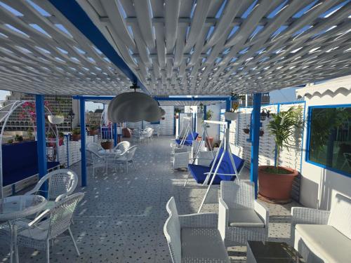 a patio with white chairs and tables on a roof at Rahhal AlBahr Serviced Apartments in Jeddah