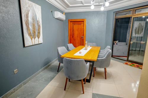 a dining room with a wooden table and chairs at RESIDENCE ISABELLA in Douala