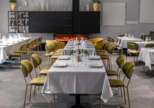 a dining room with white tables and yellow chairs at Tenuta San Marco in Noto
