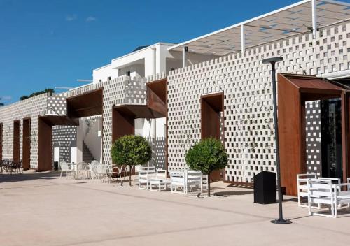 a building with tables and chairs in front of it at Tenuta San Marco in Noto