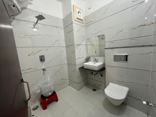 a bathroom with a toilet and a sink at Hotel The Meridian, Near Har Ke Pauri Road - Haridwar in Haridwār