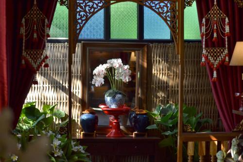 a room with a vase of flowers on a table at Thai Thai Sukhothai Resort in Sukhothai