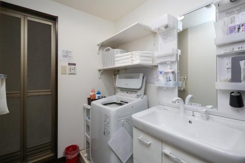金沢市にあるゲストルーム金沢心音 Guest Room Kanazawa COCONEの白いランドリールーム(洗濯機、シンク付)