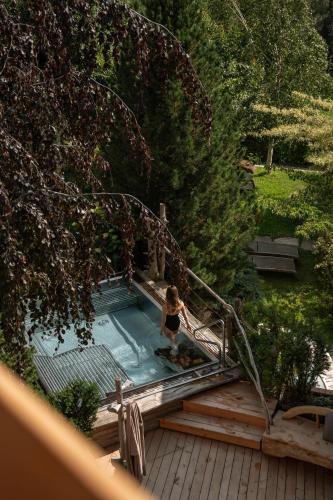 a woman is standing in a swimming pool at Lusina Apartments in Luson