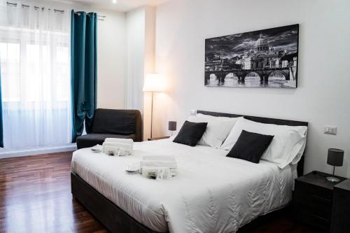 a bedroom with a large white bed and a chair at Vaticano-Cornelia Luxury Home in Rome