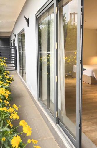 a row of glass doors on a building with yellow flowers at The Luxe Da Lat in Da Lat