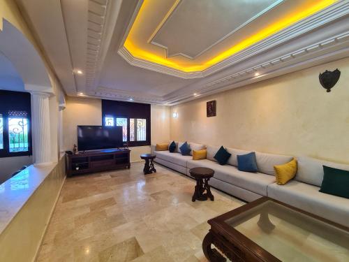 a living room with a couch and a flat screen tv at Villa spacieuse 4 chambres vue sur Océan et piscine privative in Tamaris