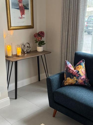 a living room with a blue chair and a table with candles at No 31 Killarney Holiday Village in Killarney