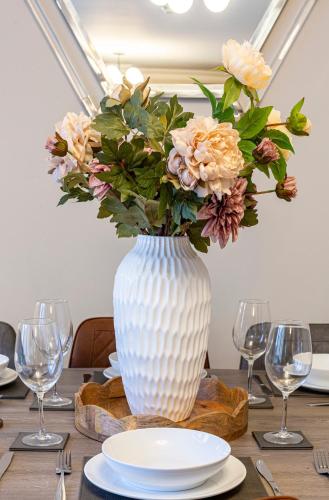 a white vase with a bouquet of flowers on a table at No 31 Killarney Holiday Village in Killarney