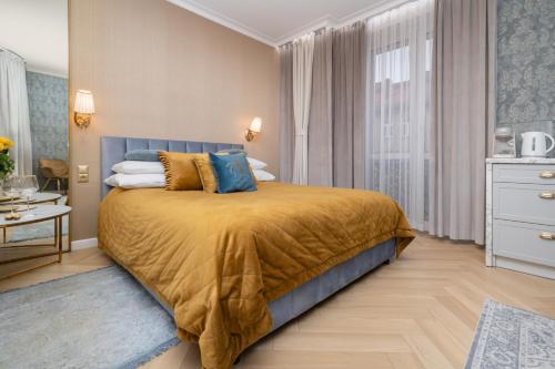 a bedroom with a bed with a yellow bedspread at Gold Apartments Jacuzzi Room in Częstochowa