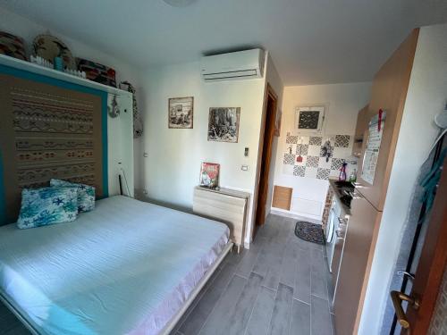 a small bedroom with a bed and a refrigerator at Il Rifugio sul Mare in Stintino