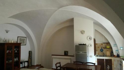 a kitchen with an arched ceiling with a table and a refrigerator at Residenza Le Volte Degli Angeli in Spello