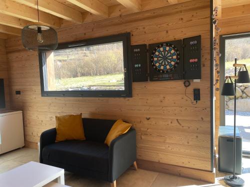a room with a couch and a dartboard on a wall at Chalet cosy 4 étoiles le Domaine Des Mésanges in Plainfaing