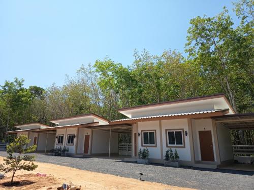 a row of modular homes with trees in the background at Good Nine Resort in Ban Lam Kaen