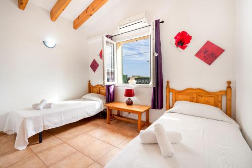 a bedroom with two beds and a window at Villa OCEANA in Cala en Porter