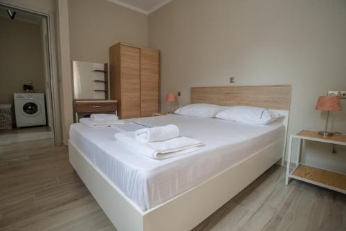 a bedroom with a large white bed with towels on it at Nirvana Homes in Vlachata