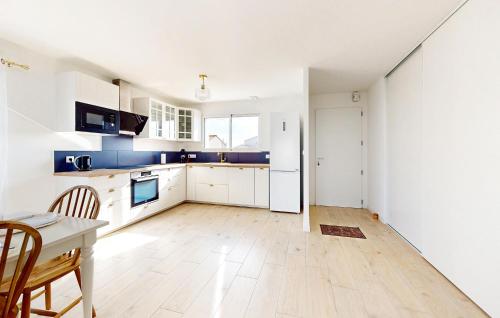une cuisine avec des armoires blanches et une table et des chaises dans l'établissement Lovely Home In Les Magnils-Reigniers, à Les Magnils-Reigniers