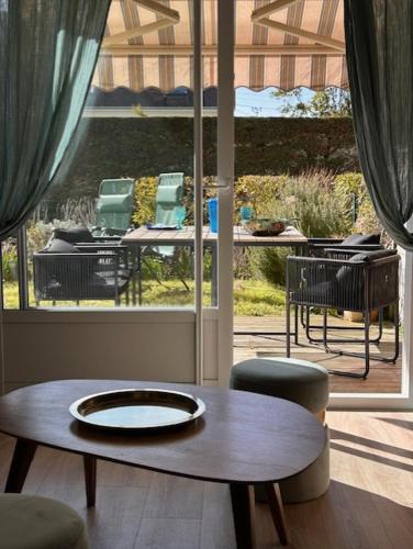 Cette chambre comprend une table, des chaises et une terrasse. dans l'établissement Appartement coquet avec jardin proche de la mer, à Ouistreham