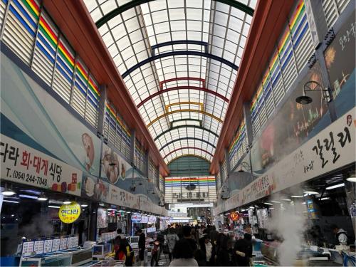 a large market with people walking around in a building at 포항 Jin house in Pohang
