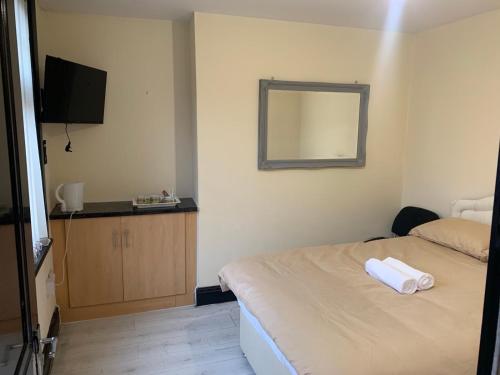 a hotel room with a bed and a mirror at Queens Hotel in Blackburn