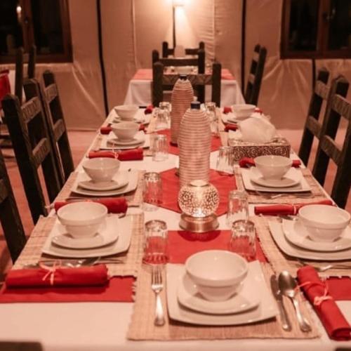 a long table with plates and dishes on it at Deep Desert Camp in Merzouga
