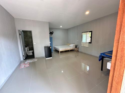 an empty living room with a bed and a television at บ้านวังปลาปาย in Pai