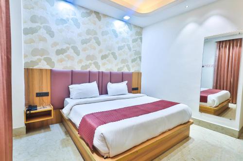 a bedroom with a large bed with a purple headboard at Orsom Stays Sassy Sector 53 in Gurgaon