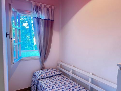une petite chambre avec un lit et une fenêtre dans l'établissement Villaggio Euroresidence, à Bibione