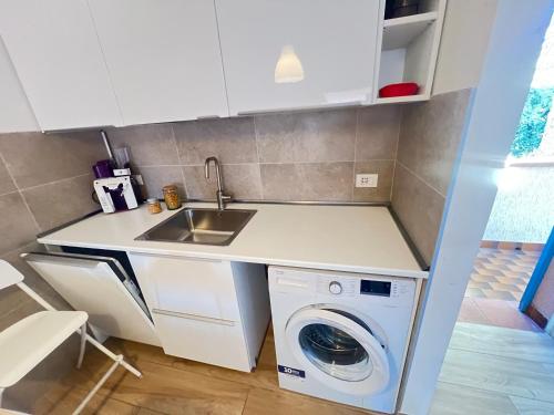 une cuisine avec un évier et une machine à laver dans l'établissement Villaggio Euroresidence, à Bibione