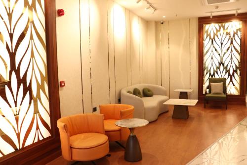 a living room with chairs and a table and a couch at Hotel Prem Inn in Vrindāvan