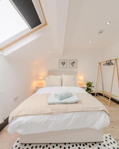 a bedroom with a large white bed with a window at Stunning Skyview 2BR flat , fast Wifi - Home Away from Home in Central Station