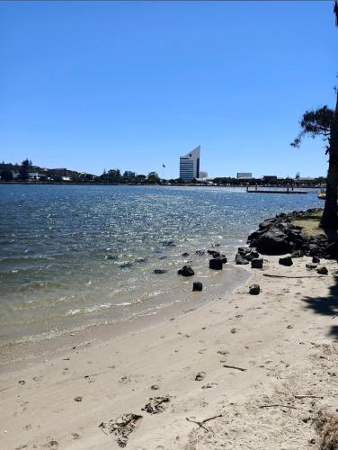 a beach with rocks on the shore of the water at Koombana Bay beach Homestay in Bunbury