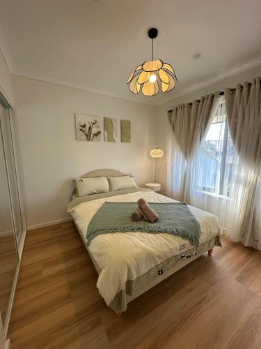 a bedroom with a bed with a teddy bear on it at Koombana Bay beach Homestay in Bunbury