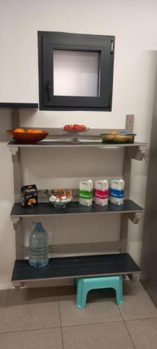 a shelf with a television and a blue stool at Casa dos ánxeles VUT-OR-1310 in Trasmiras