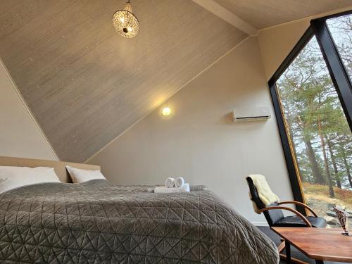 a bedroom with a bed and a large window at NorGlamp Glamping in Hjelmeland