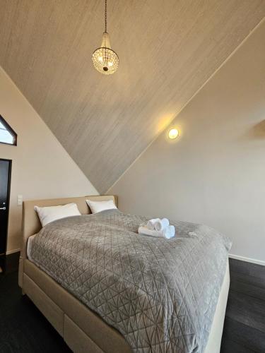 a bedroom with a bed with a gray comforter at NorGlamp Glamping in Hjelmeland