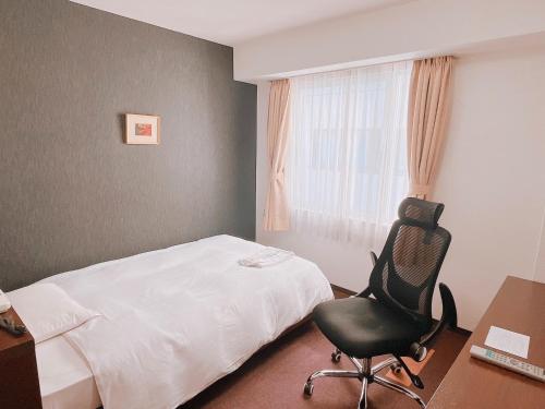 a bedroom with a bed and a chair and a desk at Hotel Shin Osaka / Vacation STAY 81494 in Osaka