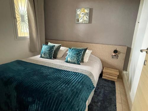 une chambre avec un lit avec des draps bleus et une fenêtre dans l'établissement Carpediem-corsica Bravone, à Linguizzetta