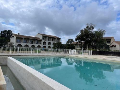 une piscine devant un immeuble dans l'établissement Carpediem-corsica Bravone, à Linguizzetta