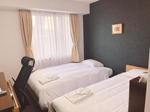 a hotel room with two beds and a window at Hotel Shin Osaka / Vacation STAY 81525 in Osaka