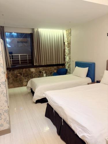a hotel room with two beds and a television at Good 9 Stay Inn in Taipei